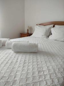 a white bed with white sheets and pillows at Quinta dos Brazilaves - Ponte de Lima in Ponte de Lima