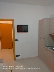 Il dispose d'une cuisine avec une télévision murale à écran plat. dans l'établissement Appartamento posizione comoda, à Collegno