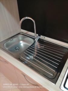 - un évier en acier inoxydable avec un robinet dans la cuisine dans l'établissement Appartamento posizione comoda, à Collegno