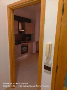 une cuisine avec une porte s'ouvrant sur une chambre dans l'établissement Appartamento posizione comoda, à Collegno