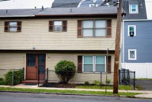 una casa marrón con una puerta roja en una calle en GREAT 2 bedroom Condo,FREE parking,easy commute. en Irvington