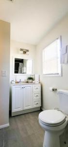 Baño blanco con aseo y lavamanos en GREAT 2 bedroom Condo,FREE parking,easy commute. en Irvington