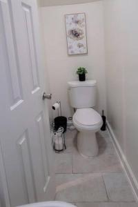 Baño blanco con aseo y puerta en GREAT 2 bedroom Condo,FREE parking,easy commute. en Irvington