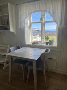 een tafel en stoelen in een keuken met een raam bij Lofoten Villa in Reine