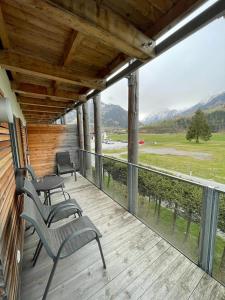 a porch with two chairs and a table on a deck at Residence Alpin Kaprun - Top 6 by Four Seasons Apartments in Kaprun