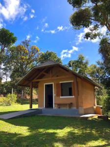 a small building with a roof on a grass field at Terrace house in Monte Verde