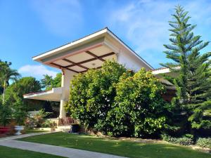 a house with a tree in front of it at Casa Aly in Santiago de los Caballeros