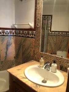 een badkamer met een wastafel, een spiegel en een bad bij Andalusialaistyyppinen, 3 makuuhuoneen asunto Casa Zarina, Puebla Aida, Mijas in Santa Fe de los Boliches