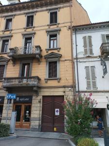 a yellow building with a brown door on a street at Il nido in Alba
