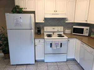 een keuken met witte apparatuur en een witte koelkast bij Paradise Canyon Golf Resort, Luxury Condo M407 in Lethbridge