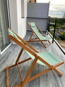 a chair on a balcony with a view at La Villa Perchée, Appartements Élégants, sauna Privé, sport, terrasses et Vue Panoramique, Parking protégé, proche PARIS in Saint-Prix