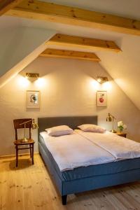 a bedroom with a large bed in a attic at Domy w Lipowie - dom różowy in Lipowo