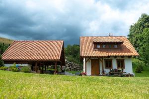 a small white house with a red roof at Domy w Lipowie - dom różowy in Lipowo