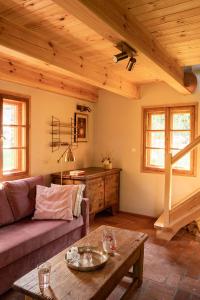 a living room with a couch and a table at Domy w Lipowie - dom różowy in Lipowo