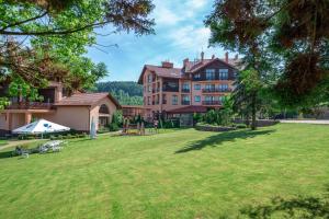 a large yard with a large house and a playground at СПА-Готель "RESPECT" in Skhidnitsa
