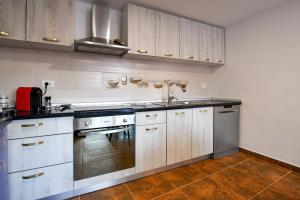 a kitchen with white cabinets and a sink at Villa CASTELLINO in Tîrgu Ocna