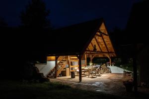 a large wooden house with a patio at night at Domy w Lipowie - dom różowy in Lipowo
