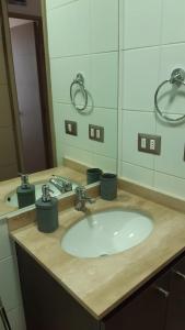 La salle de bains est pourvue d'un lavabo et d'un miroir. dans l'établissement CONDOMINIO TERRASOL 1, à Quilpué