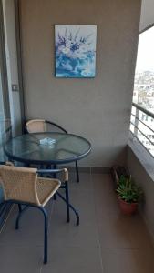 una mesa y sillas en una habitación con balcón en CONDOMINIO TERRASOL 1, en Quilpué