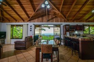 cocina y sala de estar con mesa y sillas en Bromelia House, en San Gerardo