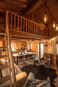 a large living room with a staircase in a cabin at HelloChalet - Chalet D'Alpage Larose - a wild back mountain escape, large sunny garden and Matterhorn views in Valtournenche