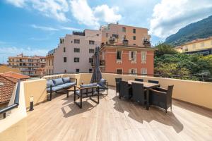 a balcony with a table and chairs on a roof at SUPERBE PENTHOUSE PROCHE MONACO GRANDE TERRASSE in Beausoleil