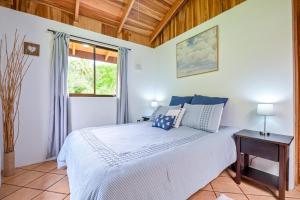 Schlafzimmer mit einem Bett und einem Fenster in der Unterkunft Bromelia House in San Gerardo