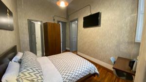 a bedroom with a bed and a tv on the wall at REPUBLICANA CASA HOSTAL - HABITACION 5 TAIRONA in Bogotá