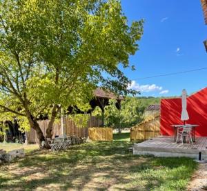 une tente rouge avec une table et un arbre dans l'établissement In the heart of artists's house, à Espiens