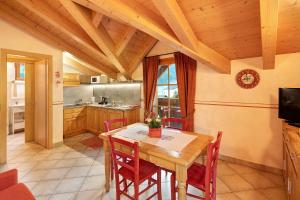 cocina con mesa de madera y sillas rojas en Stelle Chalet Martina en Livigno