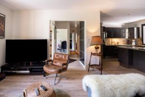 a living room with a flat screen tv and a couch at L'Alérion in Nancy
