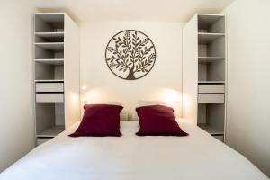 - une chambre avec un lit blanc et des oreillers rouges dans l'établissement L'Alérion, à Nancy