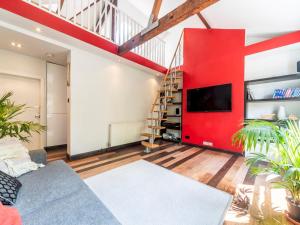 a living room with a red wall and a tv at Pass the Keys Stylish Apartment In The Heart Of Richmond in Richmond
