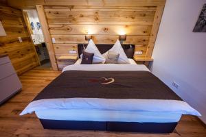 um quarto com uma cama grande e uma cabeceira em madeira em Gästehaus Holzer Kreuz- Vergissmeinnicht em Fröhnd