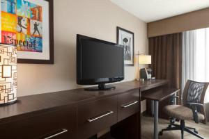 um quarto de hotel com uma secretária e uma televisão em Holiday Inn Boston Bunker Hill Area, an IHG Hotel em Somerville