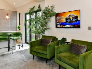 a waiting room with green chairs and a table at Pass the Keys Stunning 2 Bedroom Apartment in Heart of Pontcanna in Cardiff