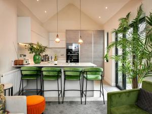 a kitchen with green bar stools and a counter at Pass the Keys Stunning 2 Bedroom Apartment in Heart of Pontcanna in Cardiff