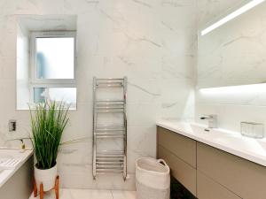 a white bathroom with a sink and a mirror at Pass the Keys Stunning 2 Bedroom Apartment in Heart of Pontcanna in Cardiff