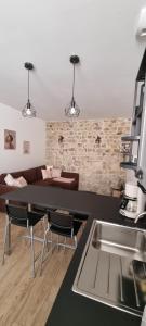 - une cuisine avec un évier, une table et un canapé dans l'établissement Appartement chaleureux en Ardèche, à Châteaubourg