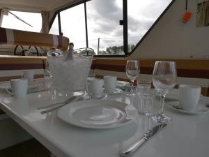 a table with a plate and wine glasses on a boat at Vivienne in Ballymoney