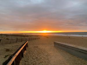 a sunset on a beach with the sun setting at Le Green-Center, 2 pièces en Hyper Centre in Soorts-Hossegor