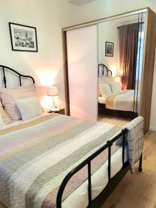 a bedroom with two beds and a large mirror at Apartament Amber Dwie Sypialnie Stare Miasto in Elblag