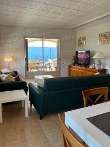 sala de estar con sofá verde y TV en El Recreo, private Pool & Bbq, en Godelleta
