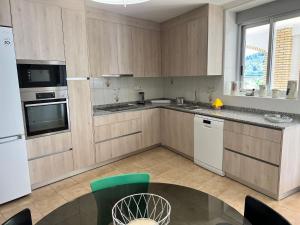 a kitchen with white appliances and a table in a room at El Recreo, private Pool & Bbq in Godelleta