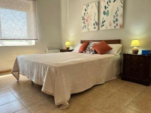 1 dormitorio con 1 cama blanca grande y 2 lámparas en El Recreo, private Pool & Bbq, en Godelleta
