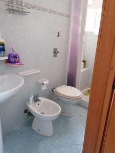 ein weißes Bad mit einem WC und einem Waschbecken in der Unterkunft Appartamento Bent el Rhia in Pantelleria