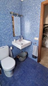 a blue tiled bathroom with a toilet and a sink at Casa Doris in San Sebastián de la Gomera