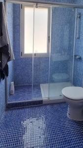 a blue tiled bathroom with a shower and a toilet at Casa Doris in San Sebastián de la Gomera