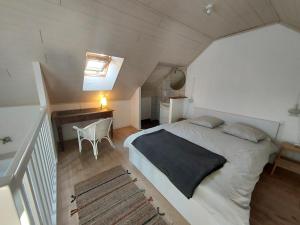 una camera da letto con letto e scrivania in mansarda di Appartement Duplex très lumineux en centre ville a Janzé