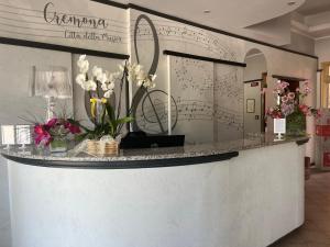 a lobby with a counter with flowers on it at Albergo Visconti in Cremona